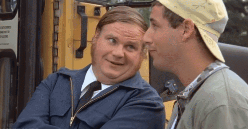 two men are sitting next to each other in front of a yellow bus and talking .