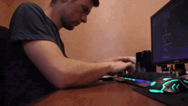a man is typing on a keyboard in front of a monitor that says philips
