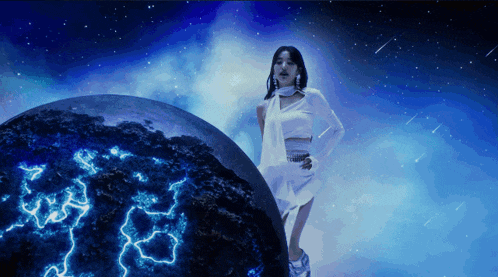 a woman in a white dress is standing in front of a glowing planet