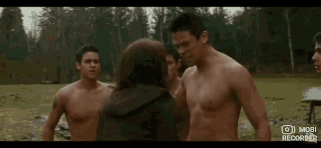 a woman is standing next to three shirtless men .