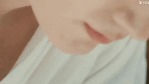 a close up of a person 's face with a white shirt on .