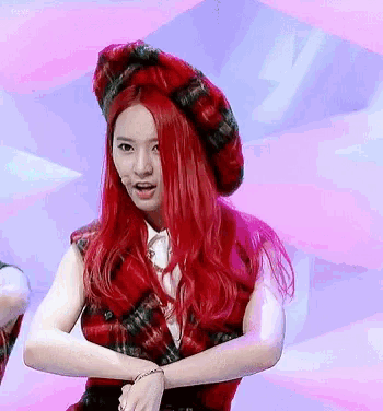 a girl with red hair wearing a plaid vest and hat