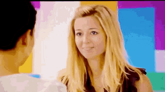 a man and a woman are looking at each other in front of a colorful background .
