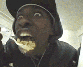 a man in a hat is eating something with a spoon in his mouth