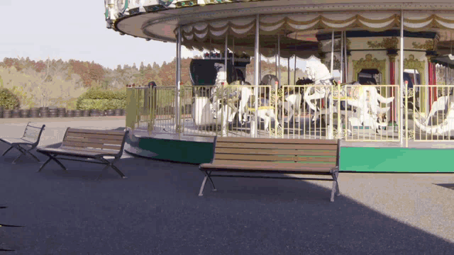 a merry go round is surrounded by a fence and benches