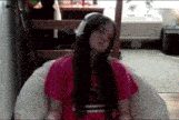 a girl wearing headphones is sitting on a bean bag chair