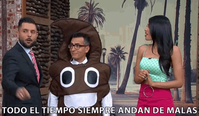 a man in a poop costume talks to a woman in a green top