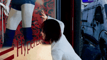 a woman is kneeling down in front of a store window that says hyperless