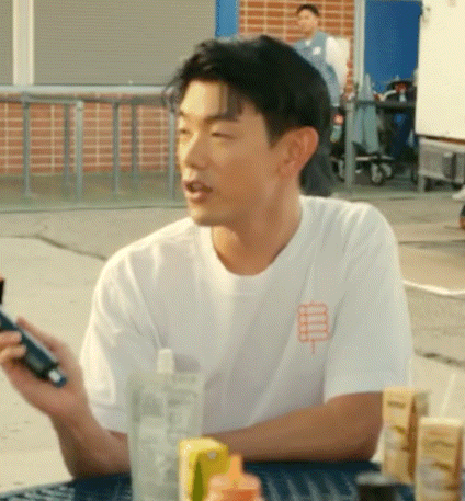 a man is sitting at a table holding a cell phone and a bottle of water .