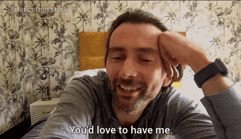 a man laying on a bed with his hand on his head and the words you 'd love to have me
