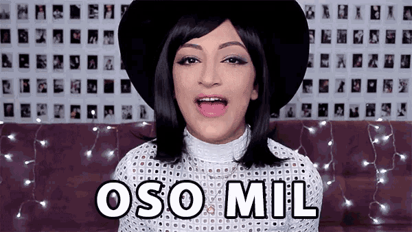 a woman wearing a black hat says oso mil in front of a wall of pictures