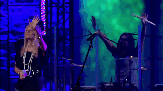 a group of people singing and playing instruments on stage