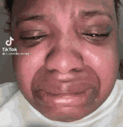 a close up of a woman 's face with tears running down her cheeks .