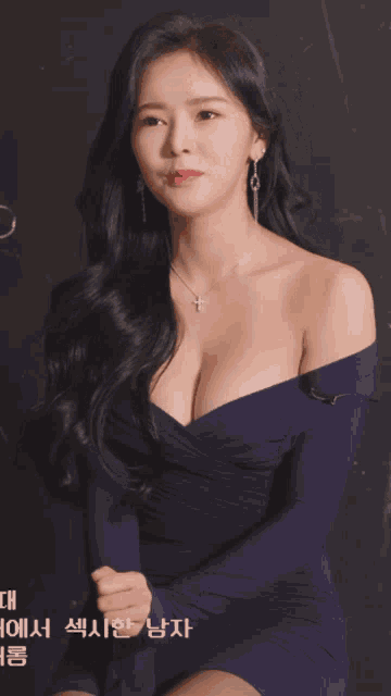 a woman in a purple dress has a cross necklace