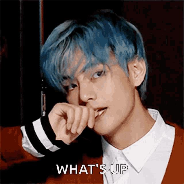 a young man with blue hair is making a face and the words what 's up are visible