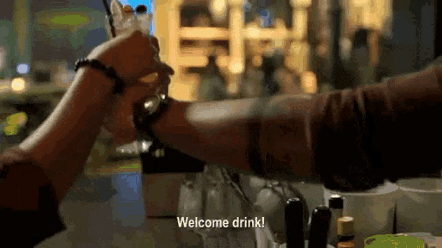 a bartender welcomes a customer with a welcome drink
