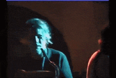 a man is playing a saxophone in a blurry photo