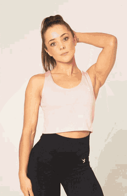 a woman is wearing a black crop top that says ambition