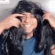 a man wearing a wig and headphones is smiling and looking at the camera .