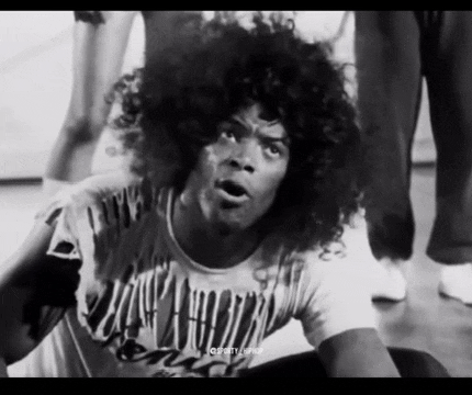 a black and white photo of a man with curly hair wearing a t-shirt that says ' dirty dancing '