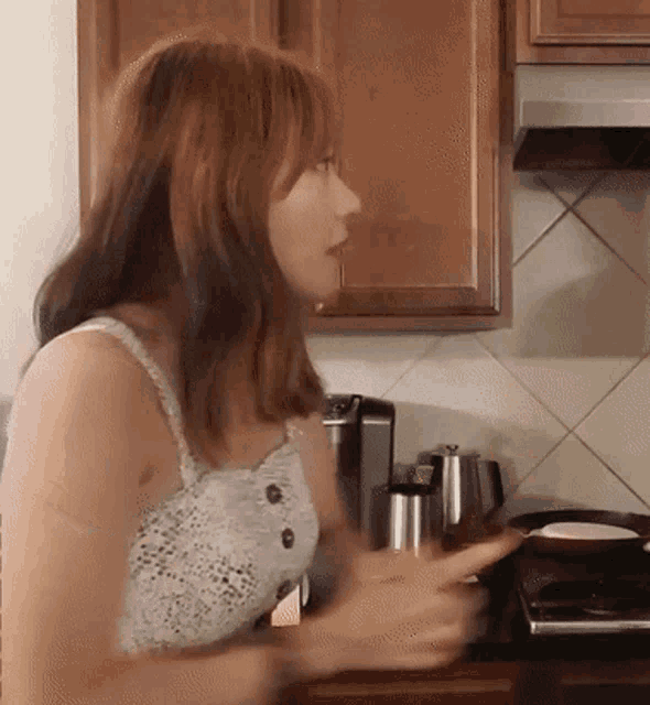 a woman in a white lace top is standing in a kitchen