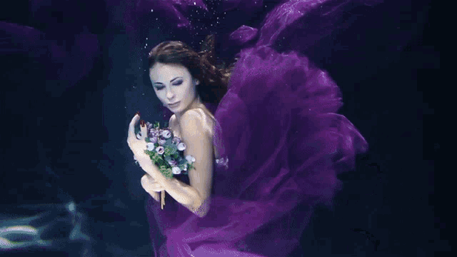 a woman in a purple dress holding a bouquet of flowers
