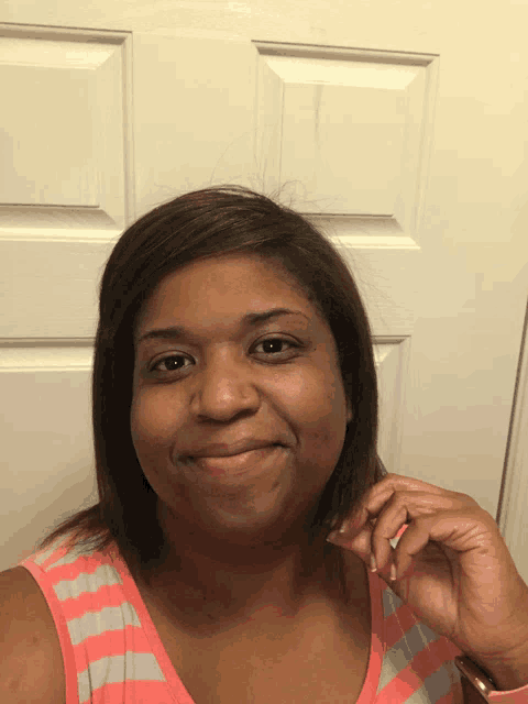 a woman is smiling in front of a door
