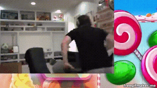 a man in a black shirt is sitting on a couch next to a lollipop