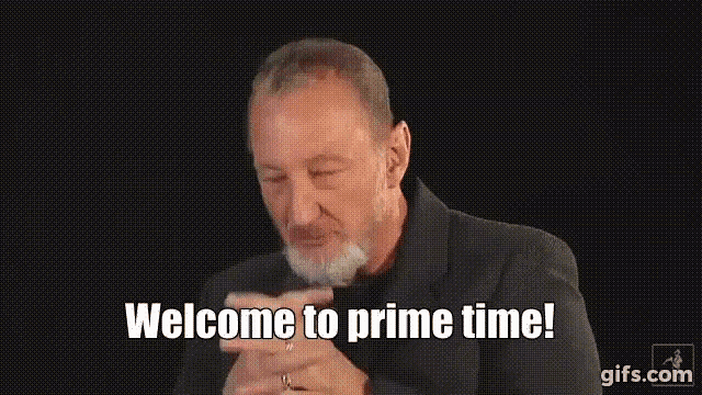 a man with a beard is making a gesture that says welcome to prime time