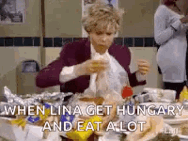 a woman is sitting at a table with a bunch of food and eating a lot .