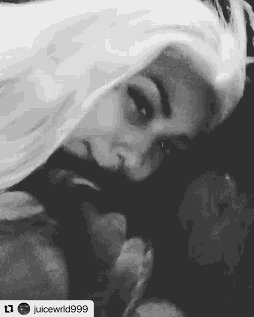 a black and white photo of a woman kissing a man .