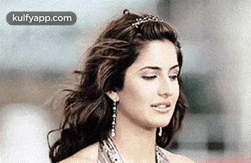 a close up of a woman 's face with her eyes closed and her hair blowing in the wind .