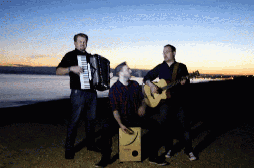 a man playing an accordion another man playing a guitar and a man playing a cajon