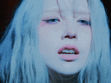 a close up of a person 's face with white hair