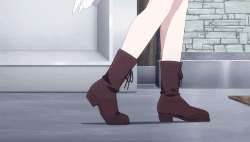 a person wearing a pair of brown boots is walking on a sidewalk