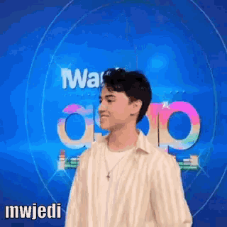 a man in a striped shirt is standing in front of a blue background with the word mwjedi on it