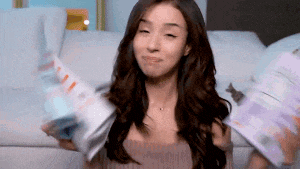 a woman is holding a bunch of magazines in her hands and making a funny face .