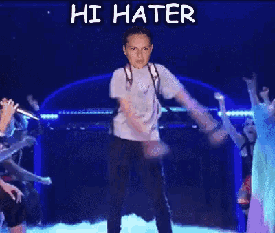 a man with a backpack is dancing on a stage with the words hi hater written above him