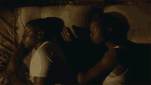 a man and a woman are laying back to back in a bed
