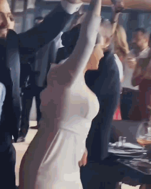 a woman in a white dress is dancing with a man