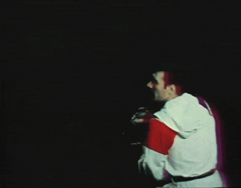 a man singing into a microphone with a red and white shirt on