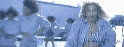 a woman in a denim jacket is dancing in a parking lot .