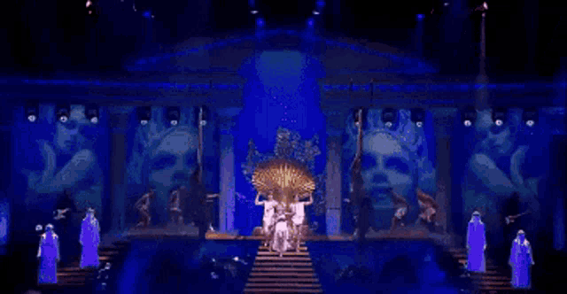 a woman in a white dress is standing on a stage with two men