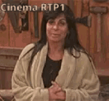 a woman in a bathrobe is standing in front of a wooden wall with the words cinema rtp1 written on it