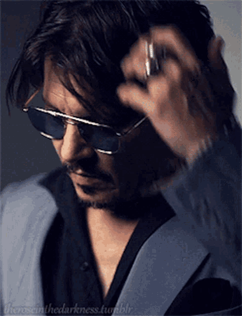a close up of a man wearing sunglasses and a suit