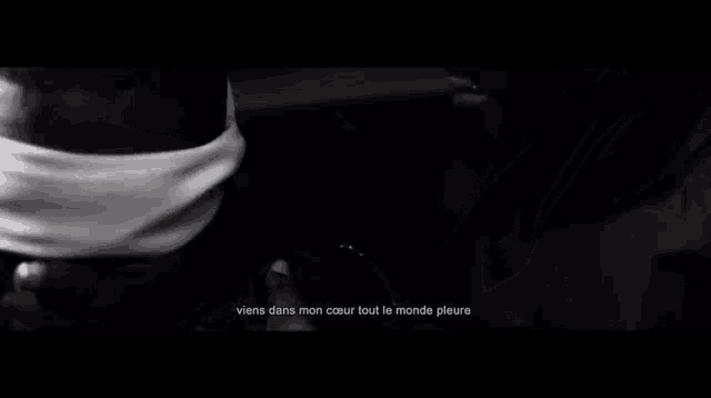 a black and white photo of a man with his eyes blindfolded and the words la nuit ma vie n'a plus de refrain