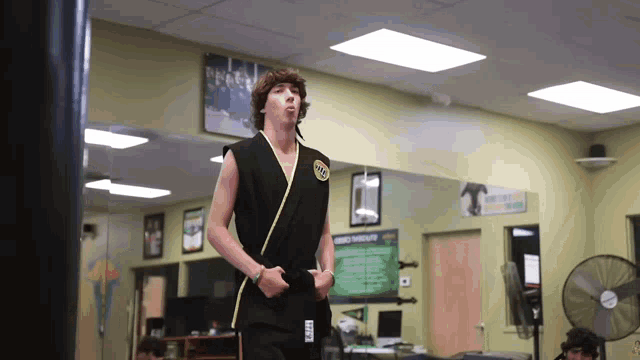 a young man in a black karate uniform with the word karate on the side