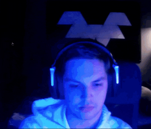 a man wearing headphones looks at the camera in front of a mickey mouse logo