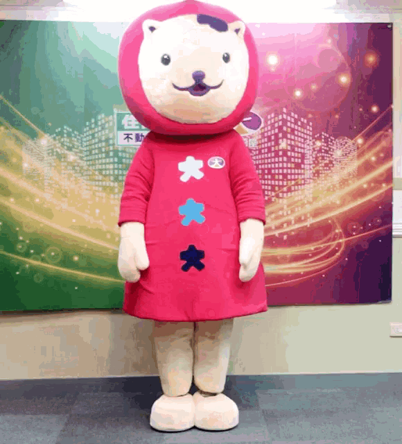 a mascot in front of a wall with chinese writing