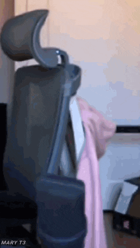 a person is sitting in a chair with their head resting on the arm rest .